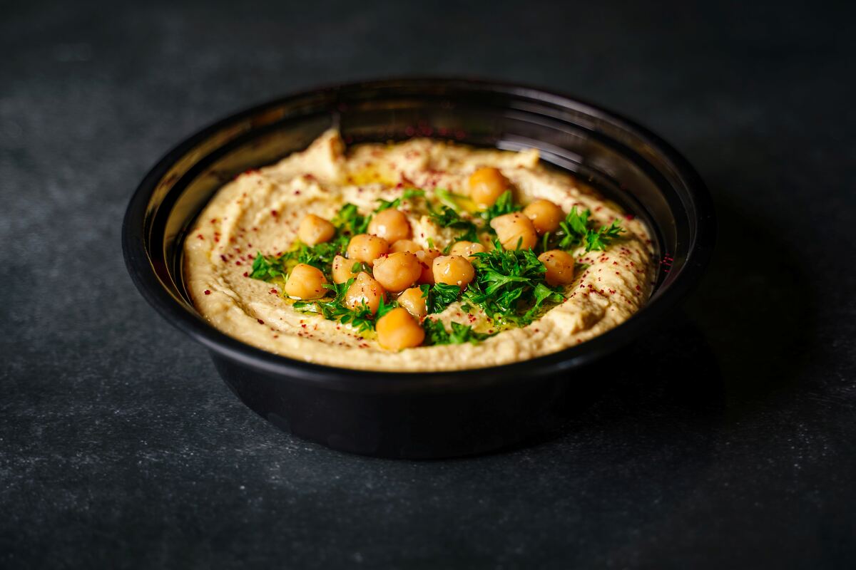 Bowl of hummus with olive oil and warm pita