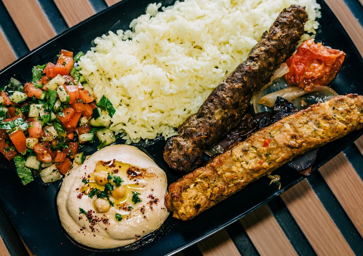 Two flame-grilled kebab skewers on rice