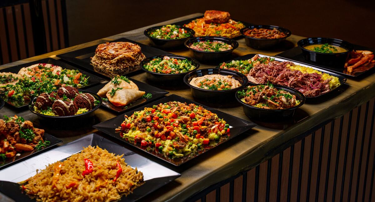 A spread of Habibi mezze: hummus, baba, salad, and pita on a table